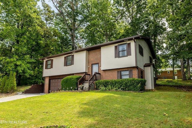 split foyer home with brick siding, driveway, an attached garage, and a front yard
