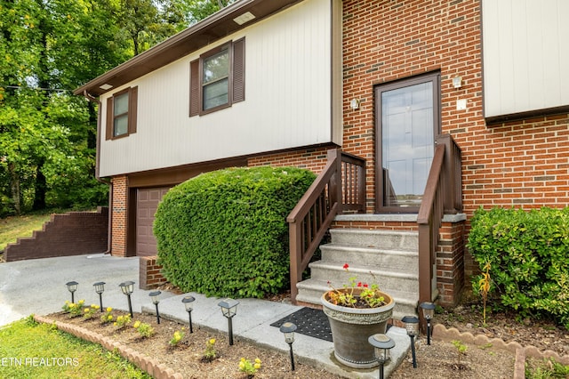 view of front of house with a garage, brick siding, and driveway