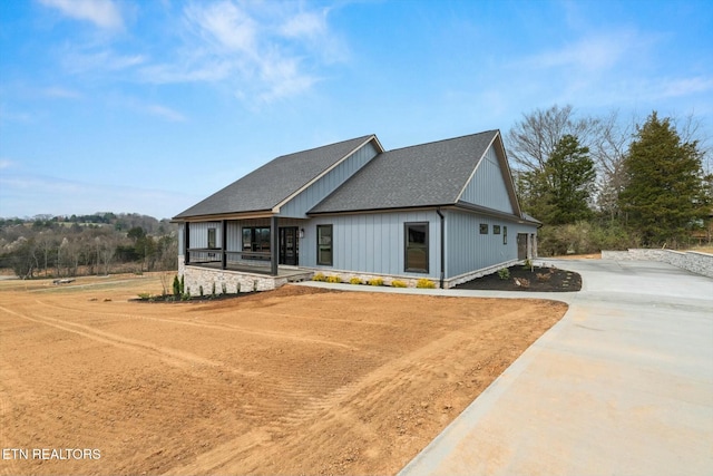 view of front of home with concrete driveway and a shingled roof