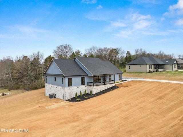 view of front of property featuring central air condition unit and stone siding