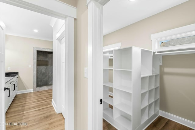 hall featuring light wood-style flooring, recessed lighting, and baseboards