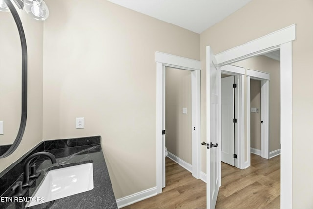 bathroom with vanity, baseboards, and wood finished floors