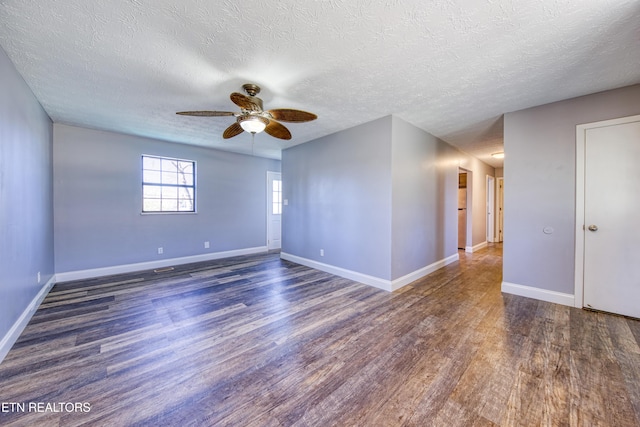 spare room featuring baseboards and wood finished floors