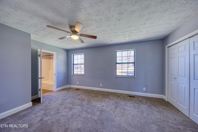 unfurnished bedroom featuring visible vents, baseboards, carpet flooring, a closet, and a textured ceiling