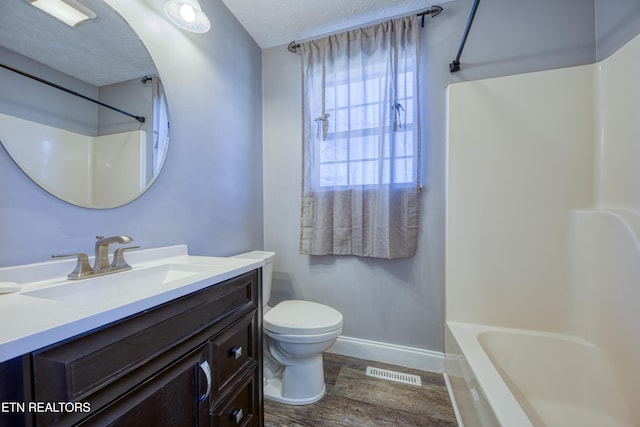 bathroom with vanity, wood finished floors, visible vents, baseboards, and toilet