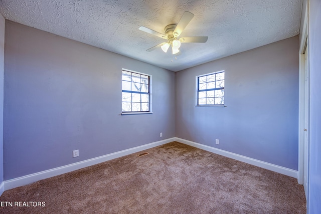 spare room featuring a ceiling fan, carpet, baseboards, and a textured ceiling