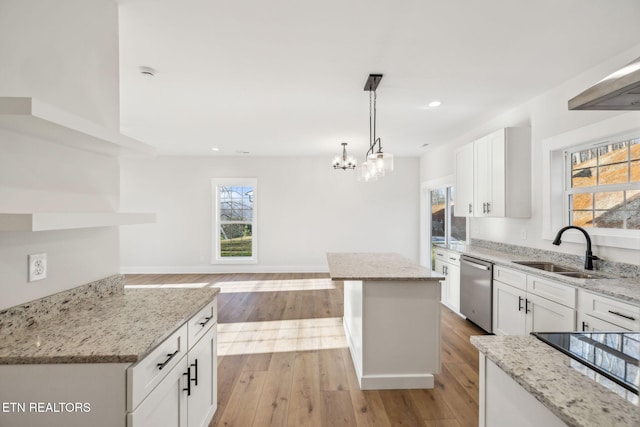 kitchen with a wealth of natural light, light wood-style flooring, dishwasher, and a sink