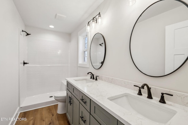 bathroom featuring a sink, toilet, walk in shower, and wood finished floors