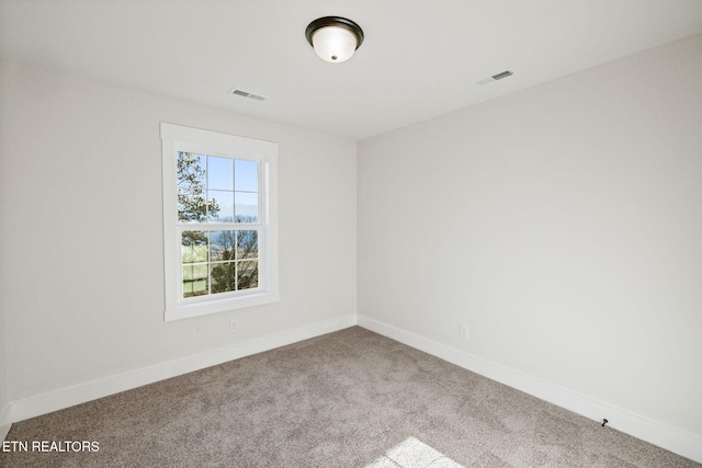 empty room with visible vents, carpet flooring, and baseboards