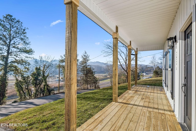 wooden terrace featuring a mountain view and a yard