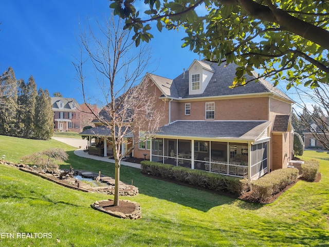 rear view of house featuring a garage, a patio, a yard, and a sunroom