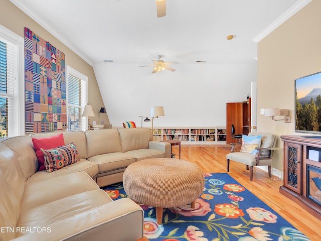 living area featuring ceiling fan, wood finished floors, visible vents, and ornamental molding