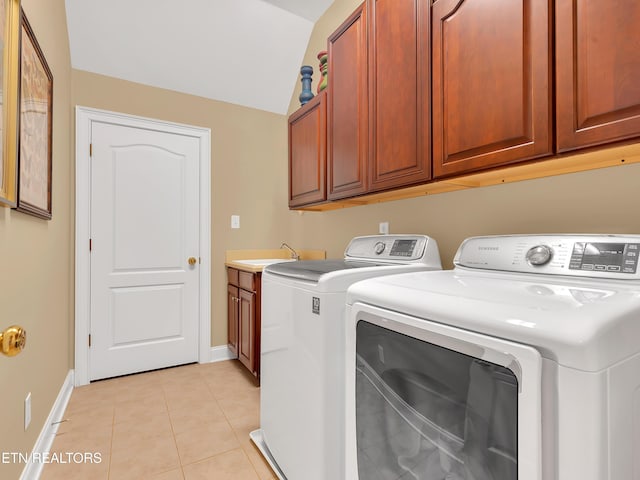 clothes washing area featuring light tile patterned flooring, cabinet space, independent washer and dryer, and baseboards