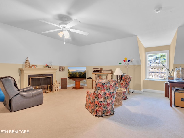 living room with baseboards, carpet floors, a ceiling fan, and a fireplace with flush hearth