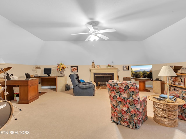 living area with a glass covered fireplace, ceiling fan, carpet flooring, and lofted ceiling