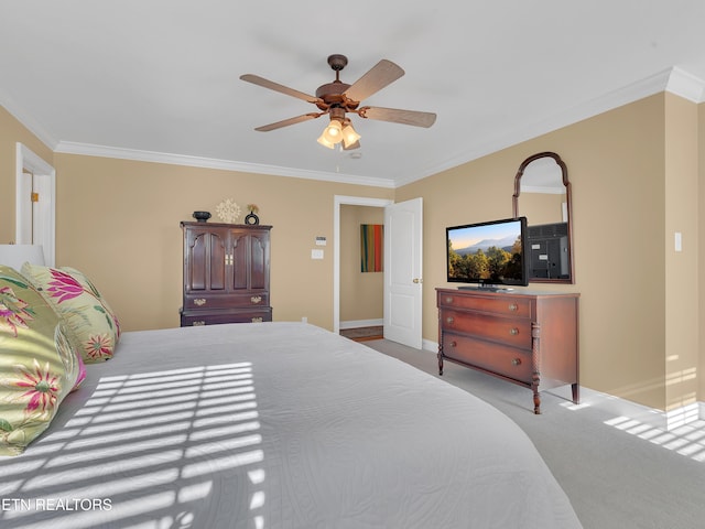 carpeted bedroom with a ceiling fan, crown molding, and baseboards