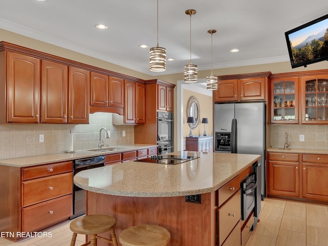 kitchen with black appliances, a sink, a kitchen breakfast bar, a kitchen island, and glass insert cabinets