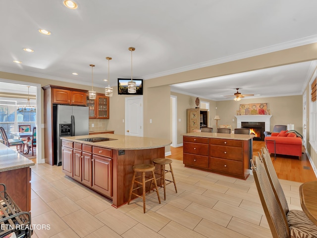 kitchen featuring backsplash, stainless steel fridge with ice dispenser, a warm lit fireplace, and a center island