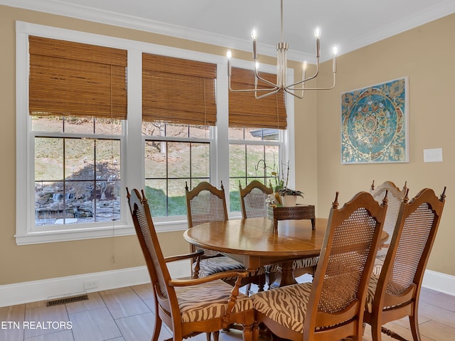 dining space featuring visible vents, baseboards, ornamental molding, and a chandelier