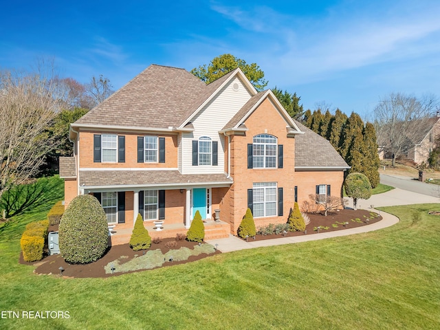 traditional home featuring brick siding and a front lawn