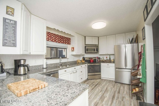 kitchen with a sink, appliances with stainless steel finishes, and white cabinets