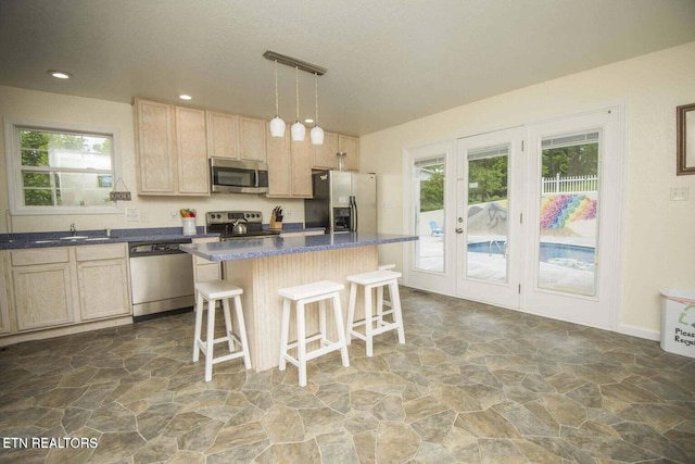 kitchen with plenty of natural light, a kitchen breakfast bar, stainless steel appliances, and stone finish flooring