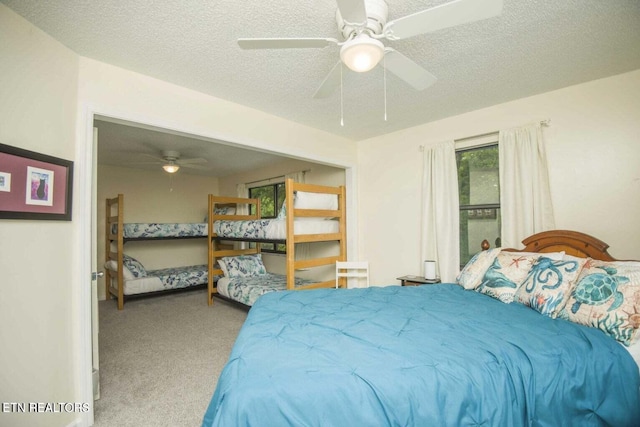 carpeted bedroom featuring a textured ceiling and ceiling fan