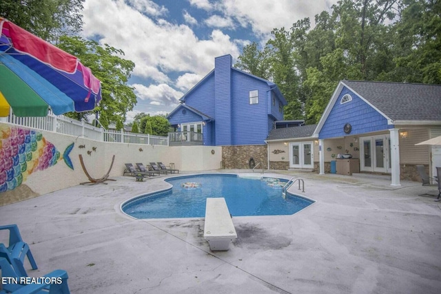 view of pool featuring french doors, fence, a fenced in pool, and a patio area