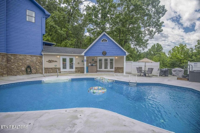 view of pool with french doors, fence, a fenced in pool, and a patio area