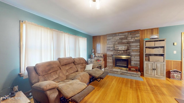 living room with wainscoting, wooden walls, wood finished floors, and a fireplace