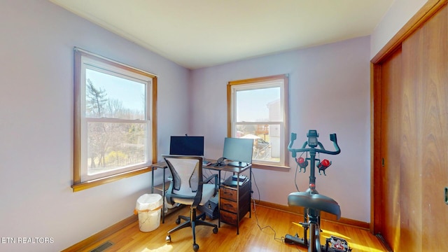 office space with visible vents, baseboards, and wood finished floors