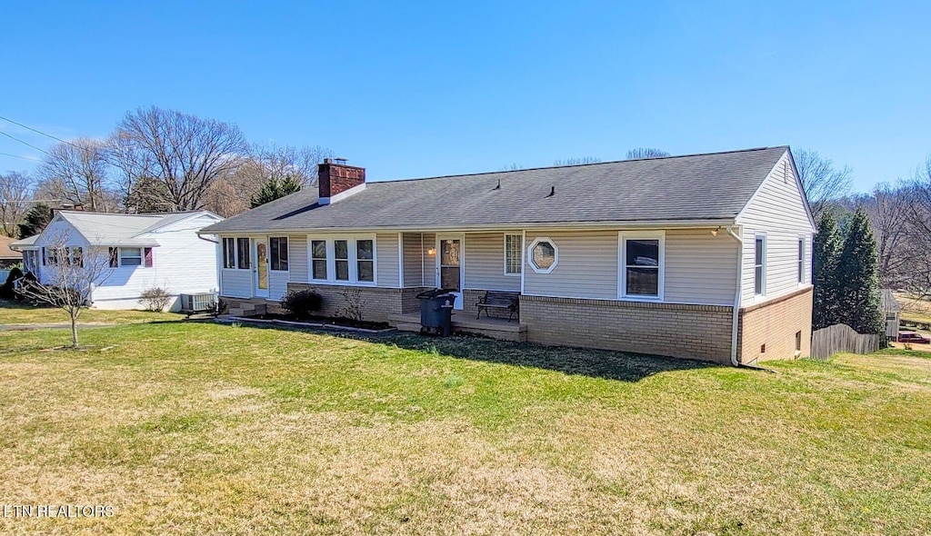 ranch-style house with central AC unit, brick siding, a chimney, and a front yard