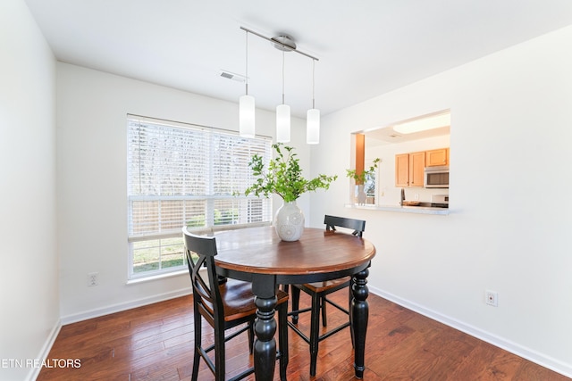 dining area with visible vents, dark wood-type flooring, and baseboards