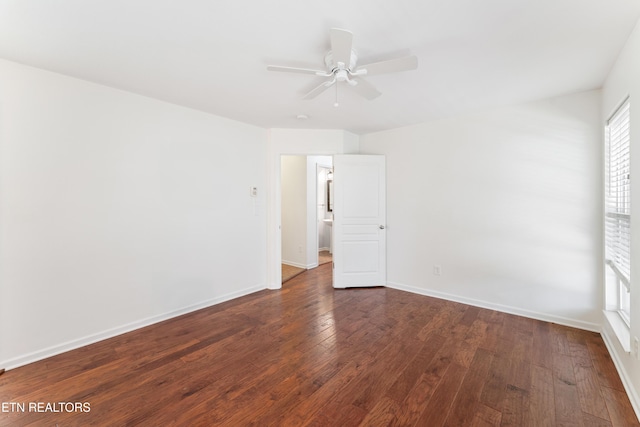 unfurnished room featuring ceiling fan, baseboards, and dark wood finished floors