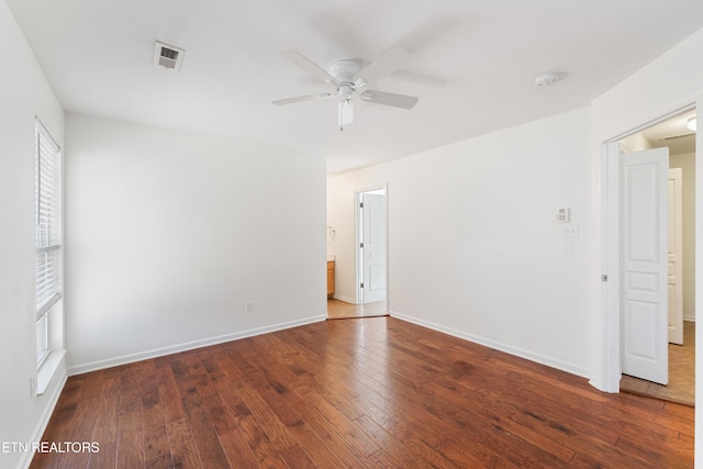 empty room with a ceiling fan, baseboards, visible vents, and wood-type flooring