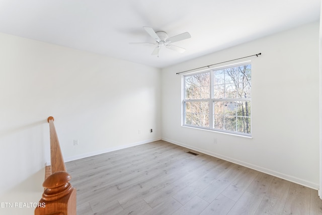 spare room featuring baseboards, light wood-style flooring, and a ceiling fan