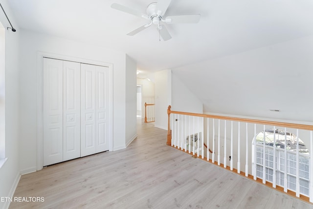 additional living space with vaulted ceiling, a ceiling fan, baseboards, and wood finished floors