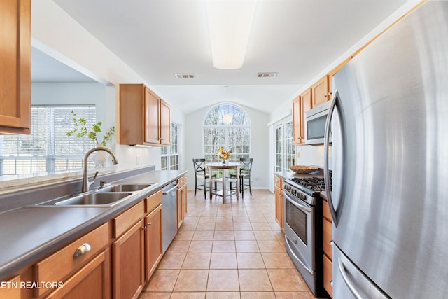 kitchen with a sink, visible vents, lofted ceiling, and appliances with stainless steel finishes