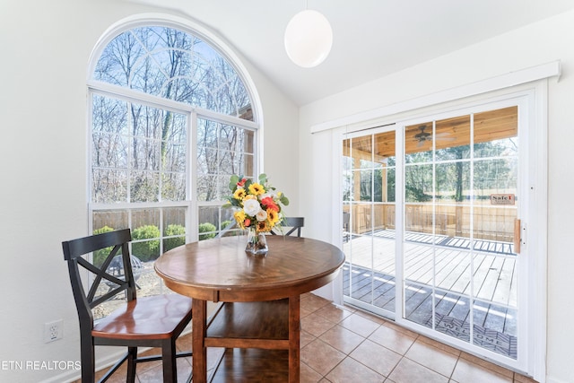 dining area with lofted ceiling, plenty of natural light, and light tile patterned flooring