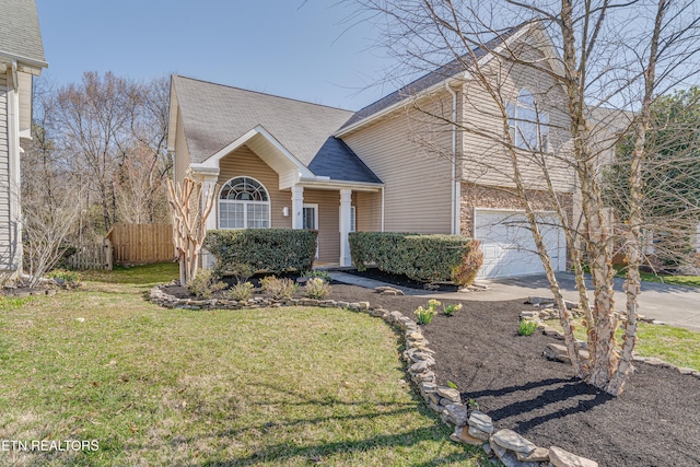 view of front of property featuring brick siding, fence, roof with shingles, a front yard, and driveway