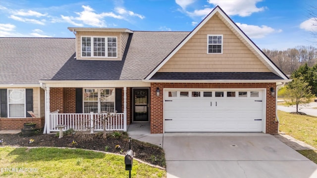 view of front of house with brick siding, a porch, a shingled roof, and driveway