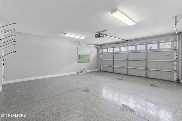 garage with a garage door opener and baseboards