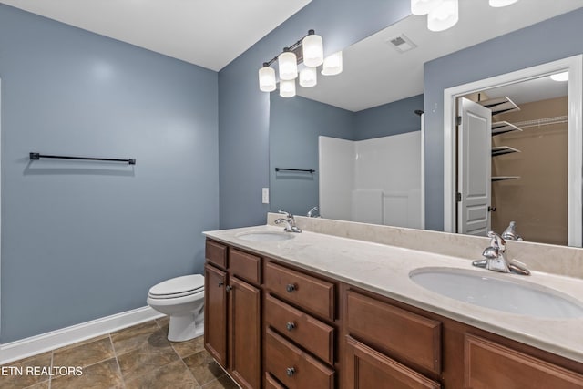 bathroom with visible vents, toilet, baseboards, and a sink
