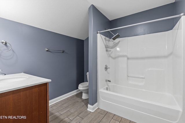 full bath featuring vanity, washtub / shower combination, baseboards, wood tiled floor, and toilet