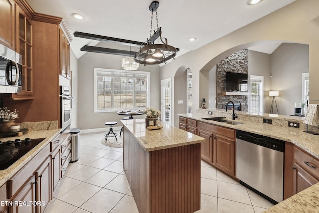 kitchen with brown cabinets, a sink, a kitchen island, appliances with stainless steel finishes, and lofted ceiling