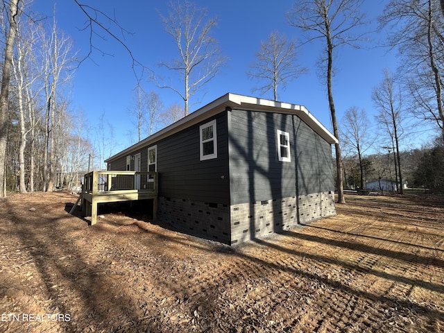 view of property exterior with a wooden deck and crawl space