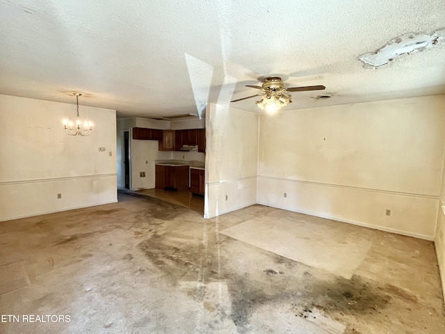 interior space with ceiling fan with notable chandelier, a textured ceiling, and concrete floors