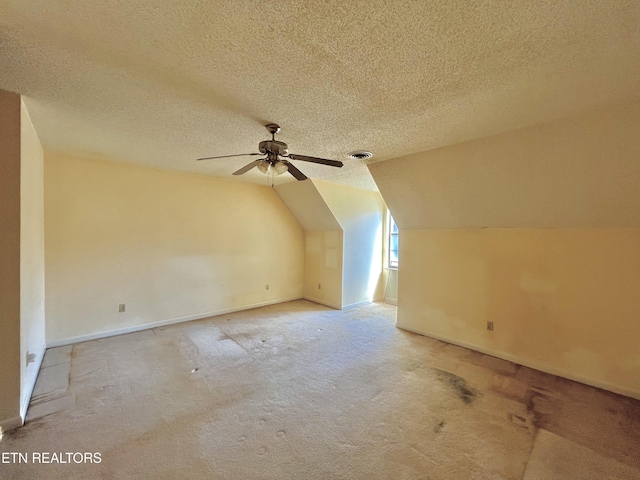 additional living space featuring visible vents, lofted ceiling, a textured ceiling, and baseboards