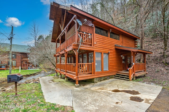 exterior space featuring a wooden deck and a patio area