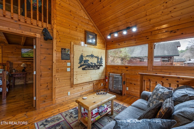 living area featuring high vaulted ceiling, wooden walls, wood ceiling, and wood-type flooring